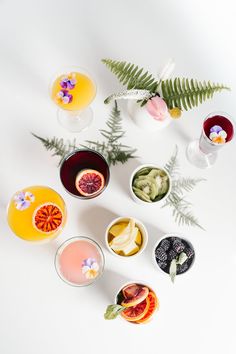 an assortment of fruit and drinks on a white surface