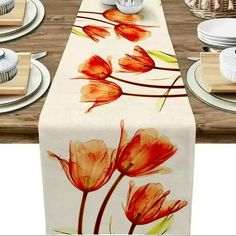 an image of a table setting with flowers on the table runner and plates in front of it