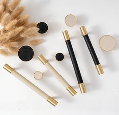 four different types of makeup brushes on a white surface next to some feathers and other accessories