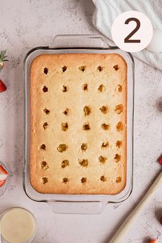 a cake in a pan with strawberries next to it