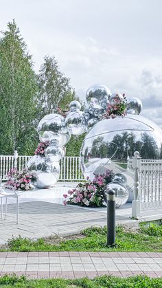 a white bench sitting on top of a lush green field next to a metal sculpture