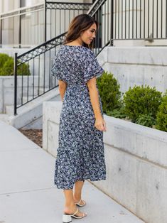 Looking for a dress that will make you stand out in a crowd? Look no further than the Floral Pattern Whitney Dress in mint floral! This dress is all about fun and flirty style, with a colorful floral print that's sure to turn heads. But it's not just about looks - this dress is designed to flatter your curves, with a tie waist that accentuates your figure. And with flutter sleeves and a midi length, it's the perfect combination of playful and sophisticated. Whether you're headed to a wedding, a Blue Floral Sundress For Garden Party, Blue V-neck Midi Dress With Ditsy Floral Print, Blue Floral Print Sundress, Blue Printed Floral Dress For Garden Party, Blue Floral Print Midi Dress, Blue Ditsy Floral Print Knee-length Dress, Flowy Blue Floral Sundress, Blue Flowy Floral Sundress, Blue Printed Midi Dress For Garden Party