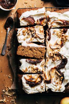 sliced cake with white frosting and nuts on top