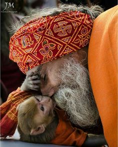 an old man with a beard is holding a small child