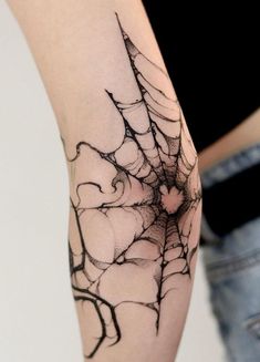 a spider web tattoo on the arm