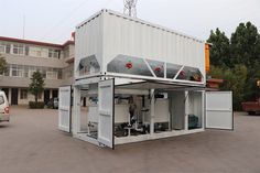 a large white container sitting in the middle of a parking lot next to a building