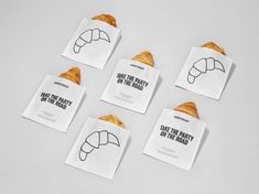 four pieces of white paper with black writing on them and some croissants in the middle