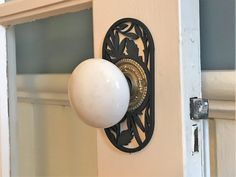 a door handle with a white ball on it and an ornate design in the middle