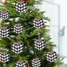 a christmas tree decorated with black and white plaid ornaments, gold baubles and red balls