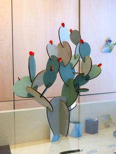 a cactus sculpture sitting on top of a counter next to a mirror in a room