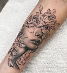 a woman's face with flowers in her hair on the left forearm and right arm