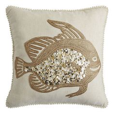 a decorative pillow with gold sequins and a fish design on the front, sitting on a white background