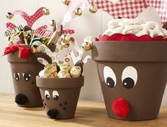 three pots filled with different types of chocolates and reindeer noses on top of a wooden table