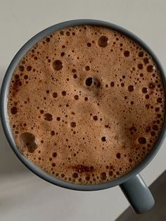 a close up of a cup of coffee on a table with the top half full