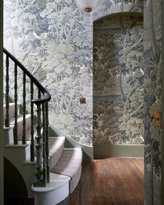 a staircase leading up to a wallpapered room