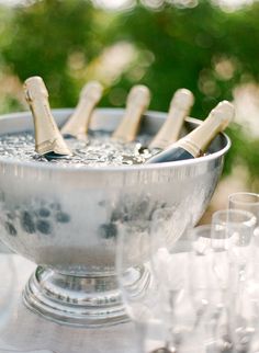 several champagne bottles in a silver bowl on a table