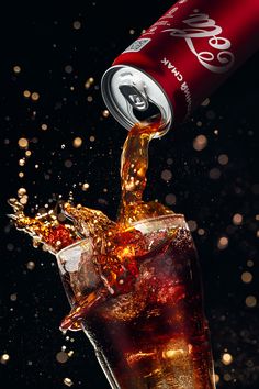 coca cola is pouring into a glass with ice