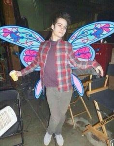 a man in plaid shirt holding up a butterfly costume