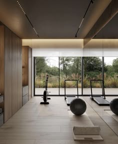 there are many exercise balls in the room with treadmills and yoga mats on the floor