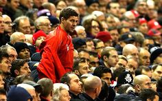 a man standing in front of a crowd of people wearing red and black jackets with one hand on his hip