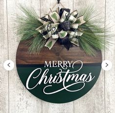 a merry christmas sign hanging on the side of a wooden wall with pine cones and evergreen leaves