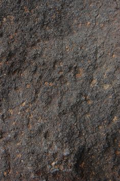 the texture of an old rock is brown and black