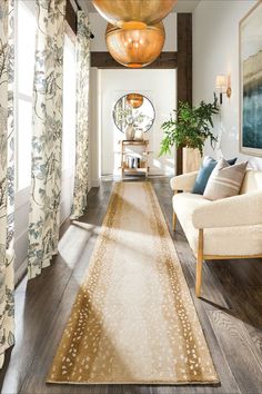 a living room filled with furniture and a rug on top of a hard wood floor