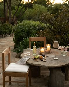 an outdoor dining table with candles on it