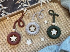 three necklaces with stars on them are hanging next to a bag and some other items