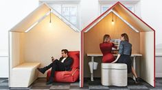 two people sitting on chairs in the shape of houses, one with a man and woman inside