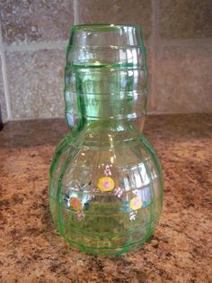 a green glass vase sitting on top of a counter