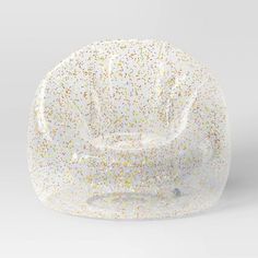 a white plastic chair with sprinkles on the back and seat cushion is shown