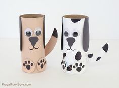 two toilet paper roll dogs sitting next to each other on a white table with black spots