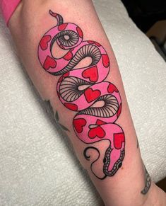 a woman's arm with a snake and hearts tattoo on the left side of her arm