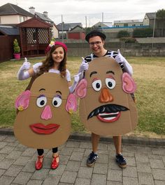 two people in costumes standing next to each other on a brick walkway with grass behind them