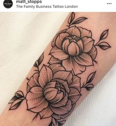 a black and white flower tattoo on the arm