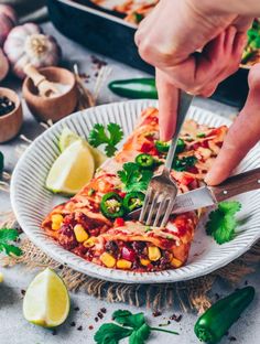 someone is cutting into a vegetable enchilada on a plate