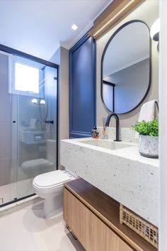 a bathroom with a sink, toilet and shower stall in the background is a large mirror on the wall