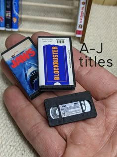 a hand holding three small cassettes in their palm