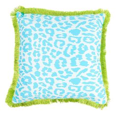 a blue and white leopard print pillow with green fringe