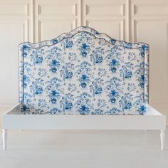 a blue and white bed frame with flowers on it