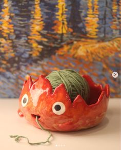 a red bowl with yarn in the shape of a crab