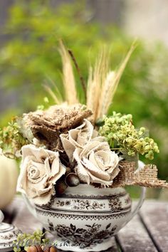 a vase filled with flowers sitting on top of a wooden table next to other items