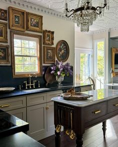 a large kitchen with an island and chandelier hanging from it's ceiling