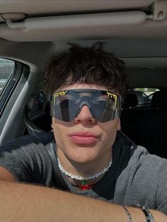 a man wearing sunglasses sitting in the back seat of a car with his arm wrapped around him