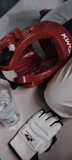 a baseball glove, mitt and water glass sitting on a table with other items