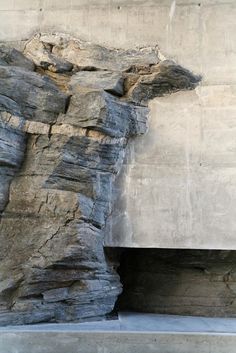 a man standing in front of a large rock formation