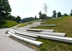 several concrete steps on the side of a grassy hill with trees in the back ground