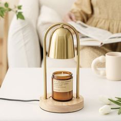 a table with a candle on it next to a coffee cup and a magazine holder