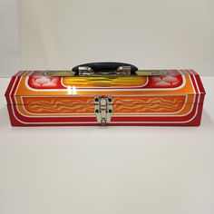 an orange, red and yellow box with a cell phone in it's lid